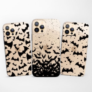 May include: Three clear phone cases with a black bat design. The cases are for an iPhone 13 Pro Max. The design on the left case features bats of various sizes scattered across the case. The design on the middle case features bats clustered together at the bottom of the case. The design on the right case features bats of various sizes scattered across the case.