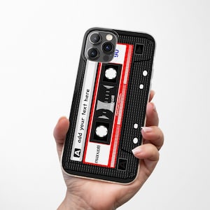 May include: A black iPhone case with a red and white cassette tape design. The case has a clear back and a black frame. The cassette tape design features the text "maxoll" and "add your text here".