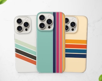 May include: Three smartphone cases featuring distinct designs. The left case is white with diagonal stripes in light green, dark gray, and orange. The center case is teal with vertical stripes in navy, magenta, and orange. The right case is cream with horizontal stripes in orange, red, and navy.