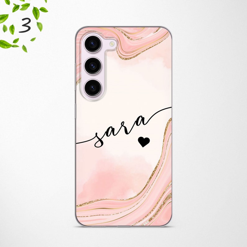 May include: A pink and gold phone case with a marble design and the name "sara" written in black cursive with a small black heart.
