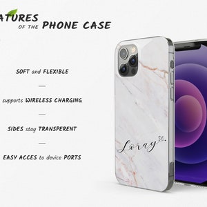 May include: A white phone case with a marble pattern and the name "Loray" written in cursive on the back. The case is compatible with wireless charging and has clear sides.