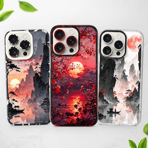 以下が含まれることがあります： 異なるデザインの携帯電話ケースが3つあります。最初のケースは、赤い月のある白黒の山岳風景です。2番目のケースは、赤い月とピンクの花のある赤と黒の山岳風景です。3番目のケースは、赤い月と白い雲のある白黒の山岳風景です。