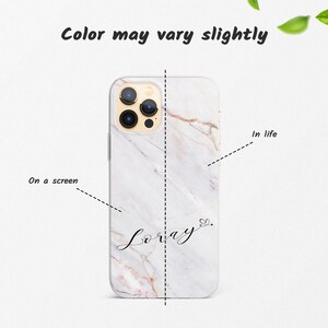 May include: White marble phone case with a gold camera lens and the name "Lorray" written in cursive with a heart.