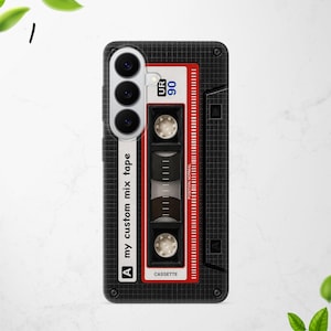 Puede incluir: Una funda de smartphone negra con un patr&oacute;n de cuadr&iacute;cula y un dise&ntilde;o gr&aacute;fico de una cinta de casete vintage. El dise&ntilde;o incluye el texto "my custom mix tape", "UR 90", "POSITION NORMAL" y "CASSETTE" con detalles en rojo y blanco.