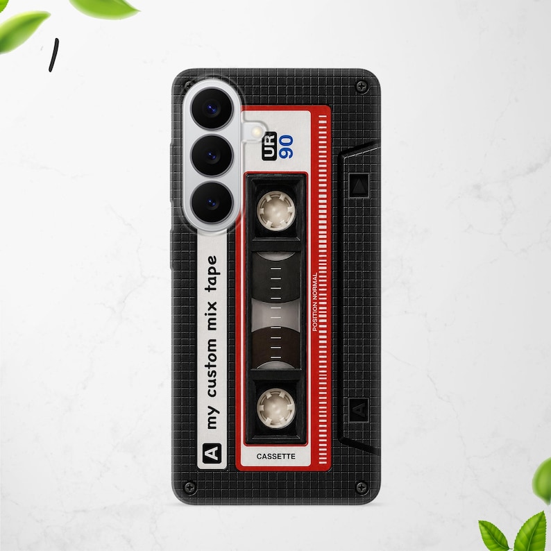 Puede incluir: Una funda de smartphone negra con un patr&oacute;n de cuadr&iacute;cula y un dise&ntilde;o gr&aacute;fico de una cinta de casete vintage. El dise&ntilde;o incluye el texto "my custom mix tape", "UR 90", "POSITION NORMAL" y "CASSETTE" con detalles en rojo y blanco.
