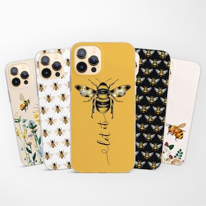 Può includere: Set di cinque custodie per telefono a tema ape. Una custodia ha uno sfondo giallo con un'illustrazione di ape e il testo "Let it bee". Un'altra custodia ha uno sfondo nero con un motivo ripetitivo di api. Una terza custodia ha uno sfondo bianco con un motivo ripetitivo di api. Una quarta custodia ha uno sfondo bianco con un design floreale e un'illustrazione di ape. La quinta custodia ha uno sfondo bianco con un design floreale e un'illustrazione di ape.