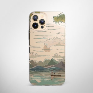 May include: A clear phone case with a Japanese-inspired design featuring a mountain landscape, a lake, and two people in a boat. The case has a gold background with a light blue and green design.