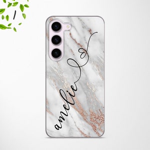 May include: A white marble phone case with a rose gold glitter design and the name "amelie" written in black cursive.