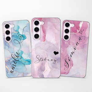 Könnte beinhalten: Drei personalisierte Handyhüllen mit abstrakten Marmormustern in Rosa-, Blau- und Lilatönen. Die Namen "Amelie", "Stefany" und "Simona" sind auf jeder Hülle in Kursivschrift geschrieben.