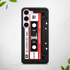 May include: A black phone case with a retro cassette tape design. The case features a red and white cassette tape with the text "UR 90", "maxoll", and "my custom mix tape".