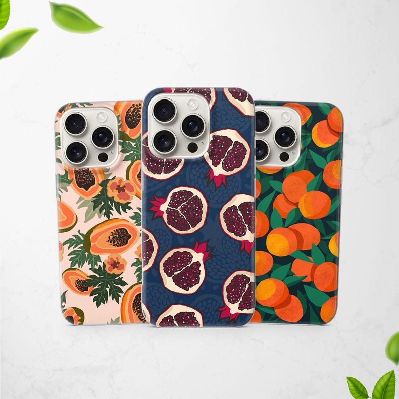 May include: Three phone cases with fruit patterns. One case has a papaya design on a pink background. Another features pomegranates on a dark blue background. The third case displays oranges and green leaves.