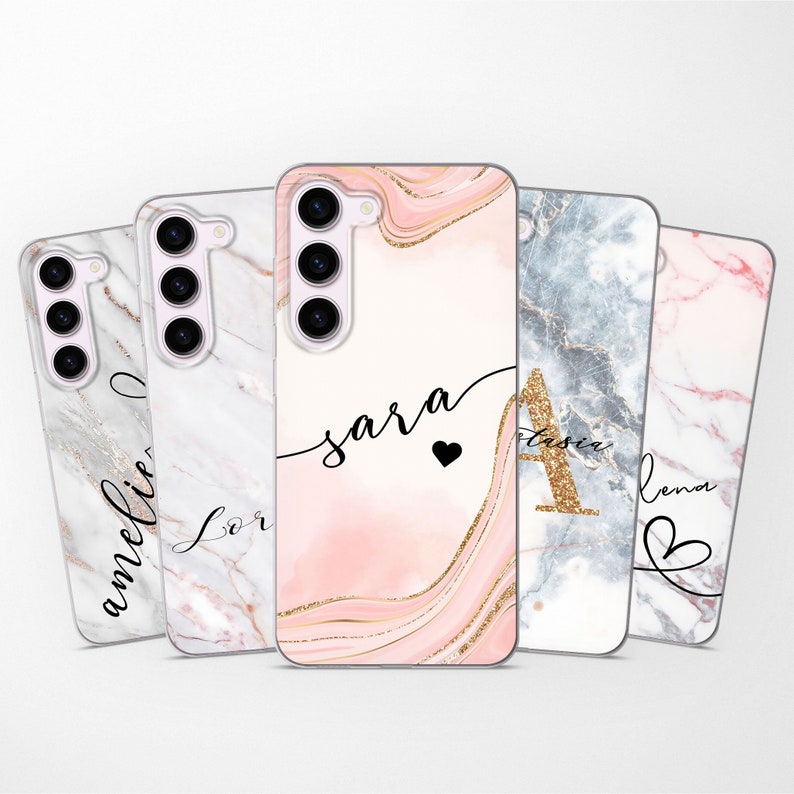 May include: Four different phone cases with marble patterns and personalized names. The cases are pink, white, gray, and light pink with gold accents. The names on the cases are Amelia, Lor, Sara, and Lena.