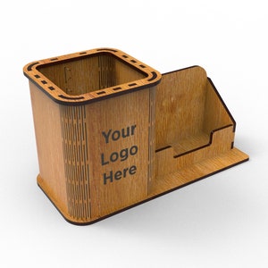 Puede incluir: Organizador de escritorio de madera con un portaplumas y un compartimento separado para tarjetas de visita. El organizador es marr&oacute;n con un patr&oacute;n de veta de madera y tiene el texto "Your Logo Here" grabado en la parte delantera.