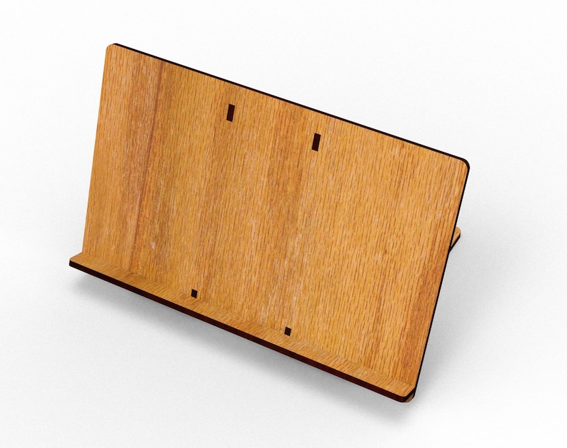 May include: A wooden book stand with a light brown finish and dark brown edges. The stand has a slanted back and a small ledge at the bottom to hold books. There are three small rectangular cutouts on the front.