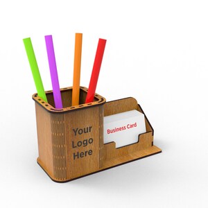 Puede incluir: Organizador de escritorio de madera con un portaplumas y un porta tarjetas de visita. El portaplumas tiene cuatro bol&iacute;grafos de colores y el porta tarjetas de visita tiene el texto "Business Card" impreso. El organizador tiene el texto "Your Logo Here" impreso.