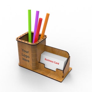 Puede incluir: Organizador de escritorio de madera con un portaplumas y un porta tarjetas de visita. El portaplumas tiene cuatro plumas: verde, morado, naranja y rojo. El porta tarjetas de visita tiene una tarjeta blanca con el texto "Business Card" impreso en ella. El organizador tiene el texto "Your Logo Here" impreso en la parte delantera.