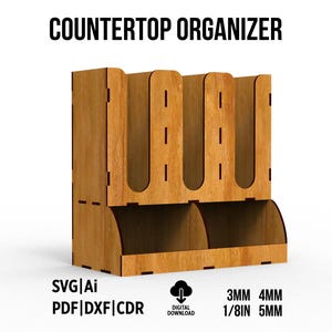 May include: A wooden countertop organizer with three vertical slots on top and two open bins at the base. The text COUNTERTOP ORGANIZER is at the top. Below are the labels SVG|Ai, PDF|DXF|CDR, a digital download icon, and 3MM 4MM 1/8IN 5MM.