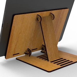 May include: A wooden tablet stand with a natural wood grain finish. The stand features a back support and a base with ventilation slots. The tablet is black and rests against the wooden back.
