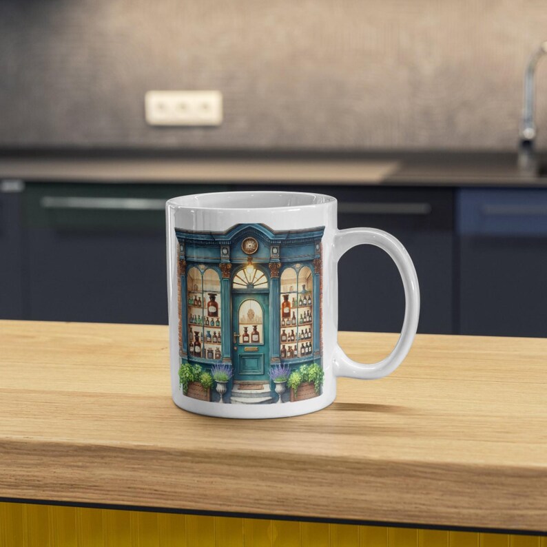 Another white ceramic mug displaying a whimsical apothecary shop illustration. The charming vintage storefront design is ideal for tea or coffee lovers, gift ideas, or custom branding for businesses and events.