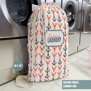 May include: A custom travel laundry bag, 28 x 36 inches, with a repeating pattern of red lobsters and navy anchors on a cream background. The bag has a drawstring closure and features the text "Cooper's LAUNDRY".