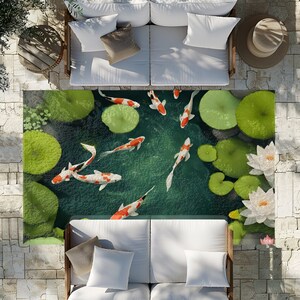 May include: A green and white area rug with a pond scene featuring orange and white koi fish swimming among lily pads. The rug is placed between two white couches with pillows.