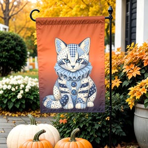 Peut inclure: Un drapeau de jardin rectangulaire illustrant un chat au motif patchwork bleu et blanc, portant une collerette à volants et deux boutons sur le poitrail. Le fond du drapeau présente un dégradé allant d'un orange vif en haut à un violet foncé en bas.