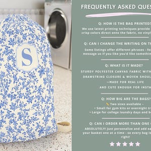 May include: A laundry bag with a blue floral pattern and a large letter "S" in a white frame. The bag is made of sturdy polyester canvas fabric with a drawstring closure and shoulder strap. The background includes a washing machine and a laundry cart.