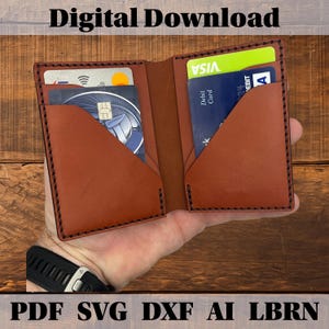 Può includere: Un portafoglio in pelle marrone con cuciture nere, contenente diverse carte di credito e di debito. Il portafoglio è aperto, mostrando gli scomparti per carte e l'interno. Il testo in alto recita "Digital Download" e in basso "PDF SVG DXF AI LBRN".