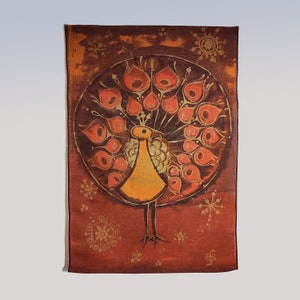 Puede incluir: Pintura rectangular de un pavo real estilizado, en tonos naranja y amarillo sobre un fondo rojo oscuro. La cola del pavo real es un diseño circular con detalles en naranja y dorado. Formas doradas en forma de copo de nieve están dispersas alrededor del pavo real.