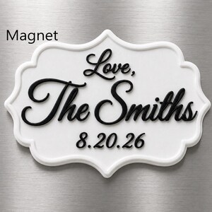 May include: A white, scalloped-edge magnet featuring raised black lettering that reads Love, The Smiths and the date 8.20.26. The text is presented in a decorative script font, centered on the plaque, with the date positioned below the name.