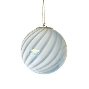 May include: A spherical, hanging light fixture with a white and light blue swirled pattern. The glass globe is suspended by a thin wire and a gold-colored metal ring.