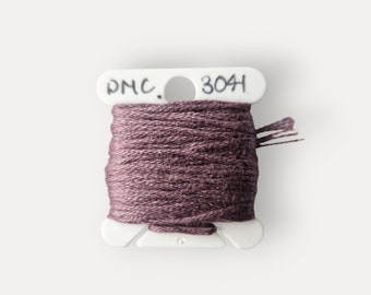 May include: A spool of DMC embroidery floss in a dark purple shade, labeled "DMC 304".