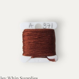 May include: A spool of brown embroidery floss with a white label that says "A 371".