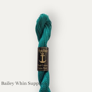 May include: A spool of teal blue Anchor Pearl Cotton embroidery floss. The label reads "Anchor Pearl Cotton Coton Perle".