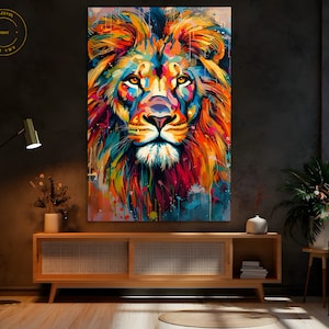 Op de afbeelding: Een kleurrijk abstract schilderij van een leeuwenkop. De manen van de leeuw zijn een mix van oranje, geel, rood en blauw. De achtergrond is lichtblauw met kleurspatten.