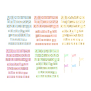 Puede incluir: Imagen que presenta bloques de letras y números en colores pastel, dispuestos en filas. Las letras y los números son dorados. También hay pequeñas banderas en colores pastel sobre palos de madera.