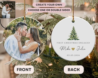 May include: A round, white ceramic ornament with a couple kissing on the front and a watercolor illustration of a Christmas tree with the text "First Christmas Engaged Mike Julia 05.05.2024" on the back.