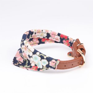 May include: A blue and pink floral patterned dog collar with a brown leather strap and gold buckle.