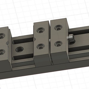 Può includere: Un sistema di guide lineari in metallo grigio con più blocchi e viti. Il sistema sembra essere progettato per un movimento e un allineamento precisi, con un focus sull'ingegneria meccanica e le applicazioni industriali.