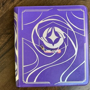 Zipper Pulls to organize Lorcana TCG binders in iridescent color. Inklands with silver clasp is shown