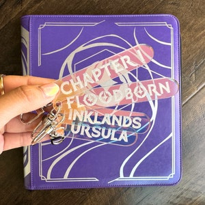 Zipper Pulls to organize Lorcana TCG binders in iridescent color. Available for Lorcana, Chapter 1, Floodborn, Inkands, and Ursula set names.