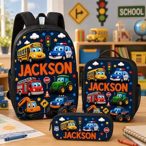 Könnte beinhalten: Ein dunkelblaues Set aus Rucksack, Lunchtasche und Federmäppchen mit Cartoon-Fahrzeugen wie einem gelben Schulbus, Polizeiauto, Feuerwehrauto, Traktor und Bagger. Jeder Artikel ist mit dem Namen JACKSON in orangefarbenen Buchstaben personalisiert.