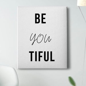 Könnte beinhalten: Weiße Leinwand-Wandkunst mit schwarzem Text, der "BE you TIFUL" lautet.