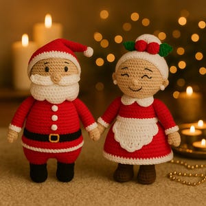 Pode incluir: Bonecos de Natal de crochê, Papai Noel e Mamãe Noel. Papai Noel veste um traje vermelho com cinto preto e barba branca. Mamãe Noel usa um vestido vermelho e um avental branco. Ambos estão de mãos dadas.