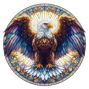 Könnte beinhalten: Ein kreisförmiges Buntglas-Kunstwerk, das einen Adler mit ausgebreiteten Flügeln darstellt. Die Federn des Adlers sind braun, weiß und goldfarben, mit blauen und violetten Akzenten auf den Flügeln. Das Design wird von floralen und geometrischen Mustern umrahmt.