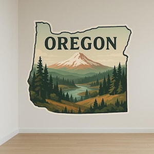 Puede incluir: Un vinilo decorativo con la forma de Oregón, que presenta un paisaje escénico. El diseño incluye una montaña nevada, un río y árboles de hoja perenne, con la palabra "OREGON" en la parte superior. La paleta de colores es apagada, con verdes, marrones y azules.