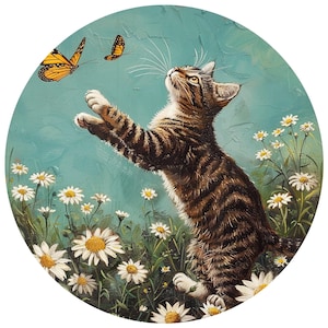 May include: A round painting of a tabby cat reaching for two orange and black butterflies. The cat is in a field of white daisies with green stems and leaves. The background is a light blue color.