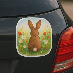 Adesivo per camper, laptop o auto raffigurante un coniglio su un prato fiorito. Delicato motivo animale come regalo per gli amanti del giardino e per i bambini.