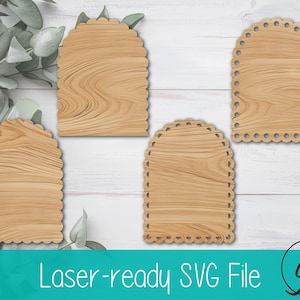 Puede incluir: Cuatro recortes de madera en forma de arco con bordes festoneados y textura de vetas de madera. Los recortes están dispuestos sobre una superficie de madera blanca con vegetación. El texto "Laser-ready SVG File" está en la parte inferior.