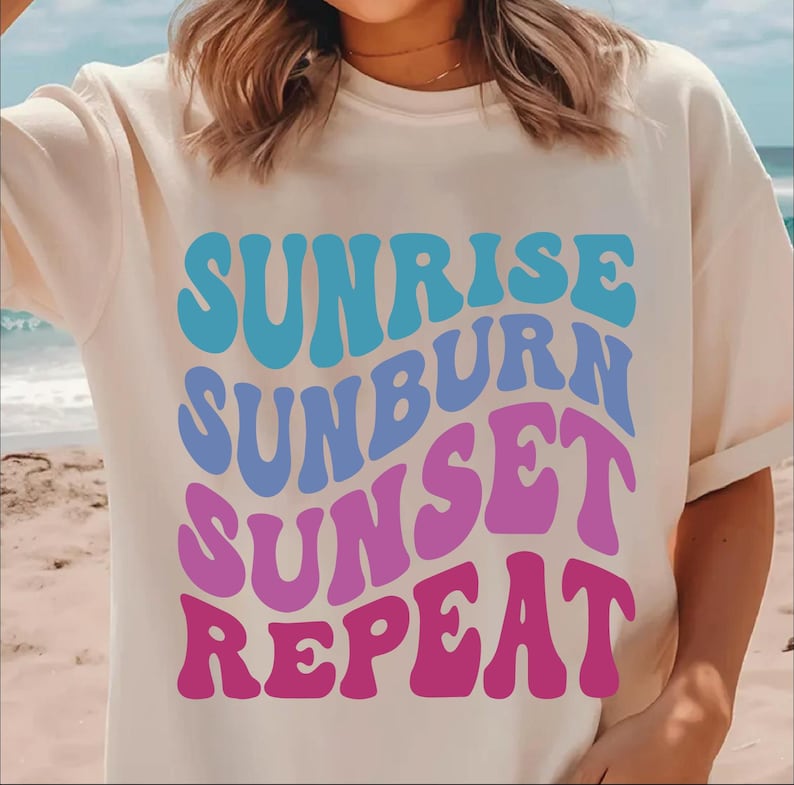 Peut inclure: T-shirt blanc avec un imprim&eacute; graphique du texte "Sunrise Sunburn Sunset Repeat" en bleu, violet et rose.